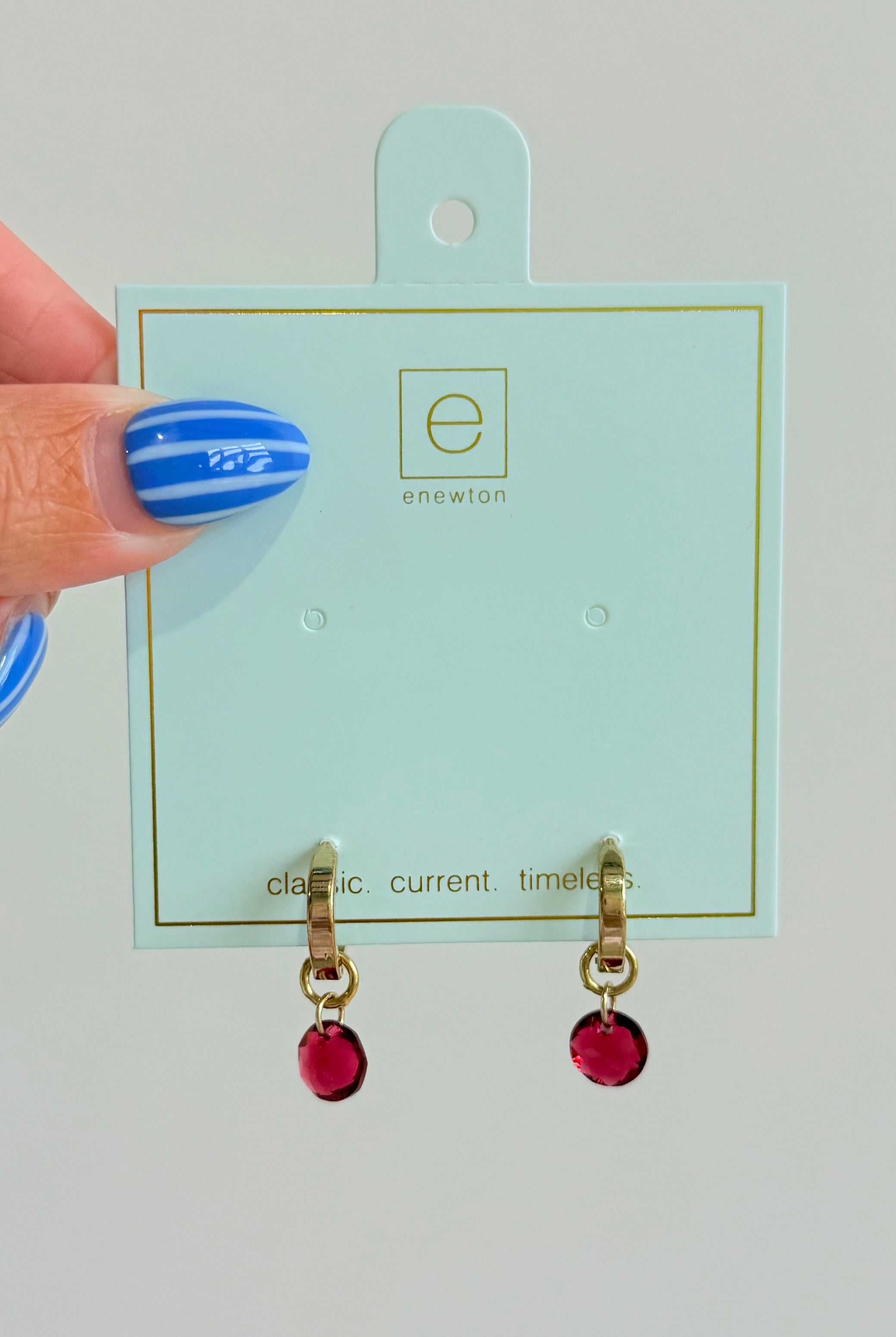 Enewton .5mm classic birthstone huggie earrings featuring small, sparkling gemstones in a silver-tone metal setting.