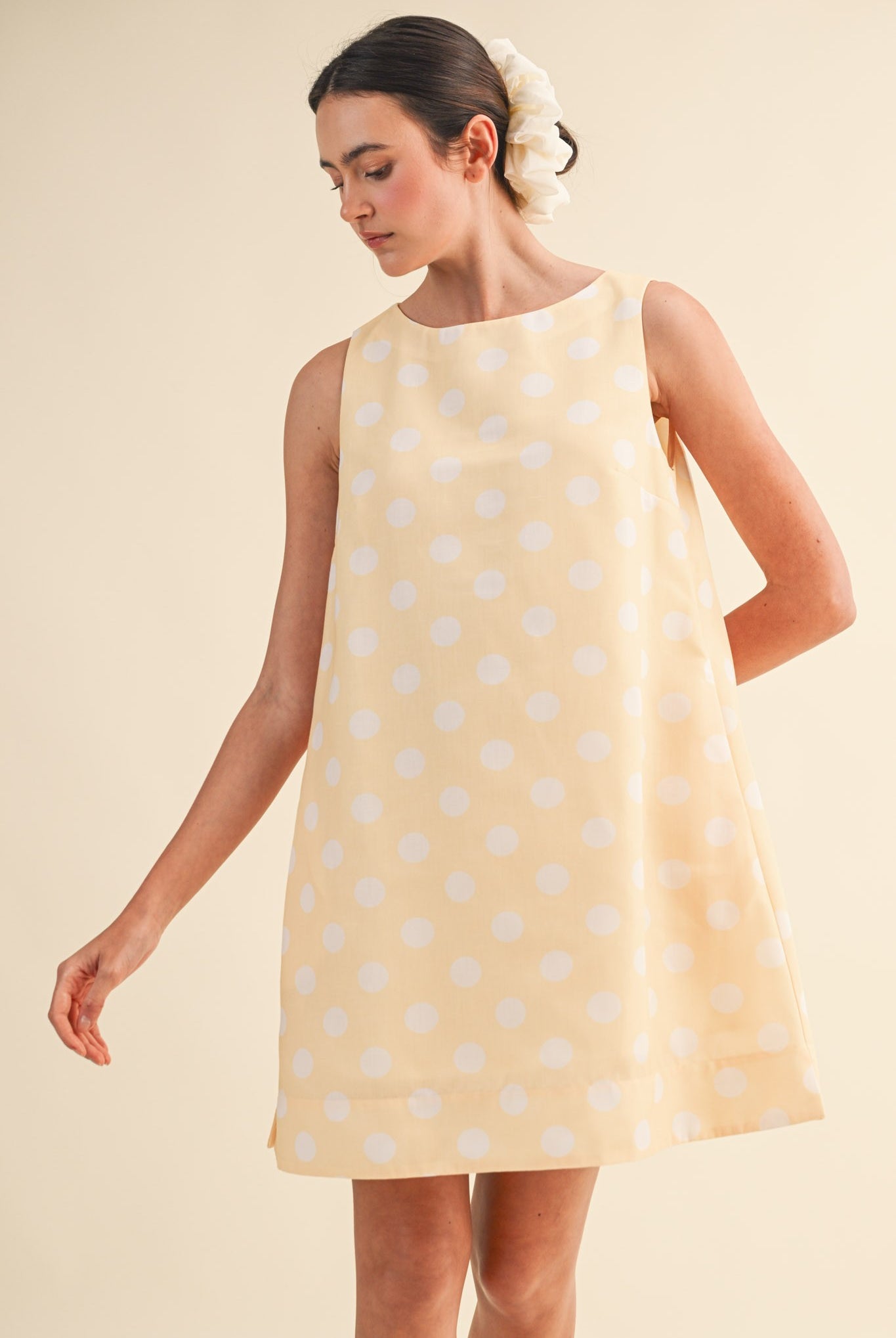 &MERCI Lola Polka Dot Sleeveless Dress with fitted bodice and flared skirt, featuring classic black and white polka dot pattern.