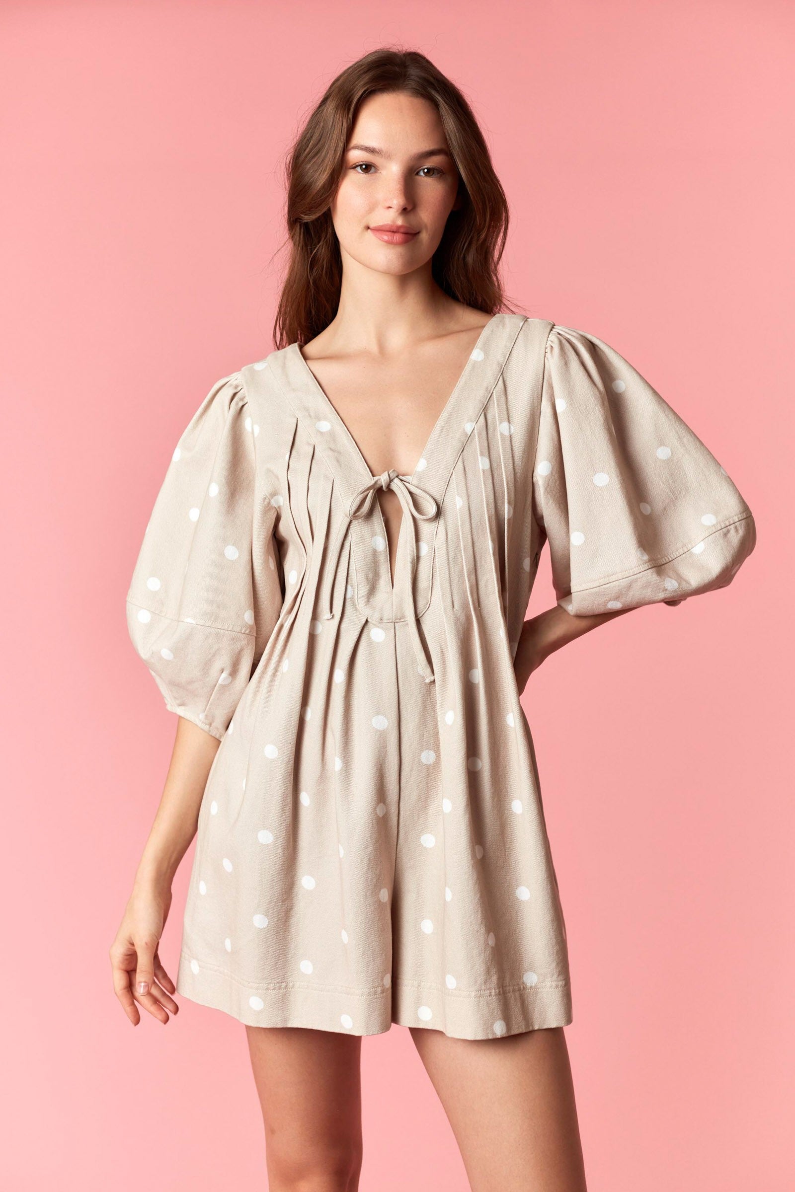 Loran taupe pleated polka dot romper by PEACH LOVE, featuring a relaxed fit with pleats and polka dot pattern.