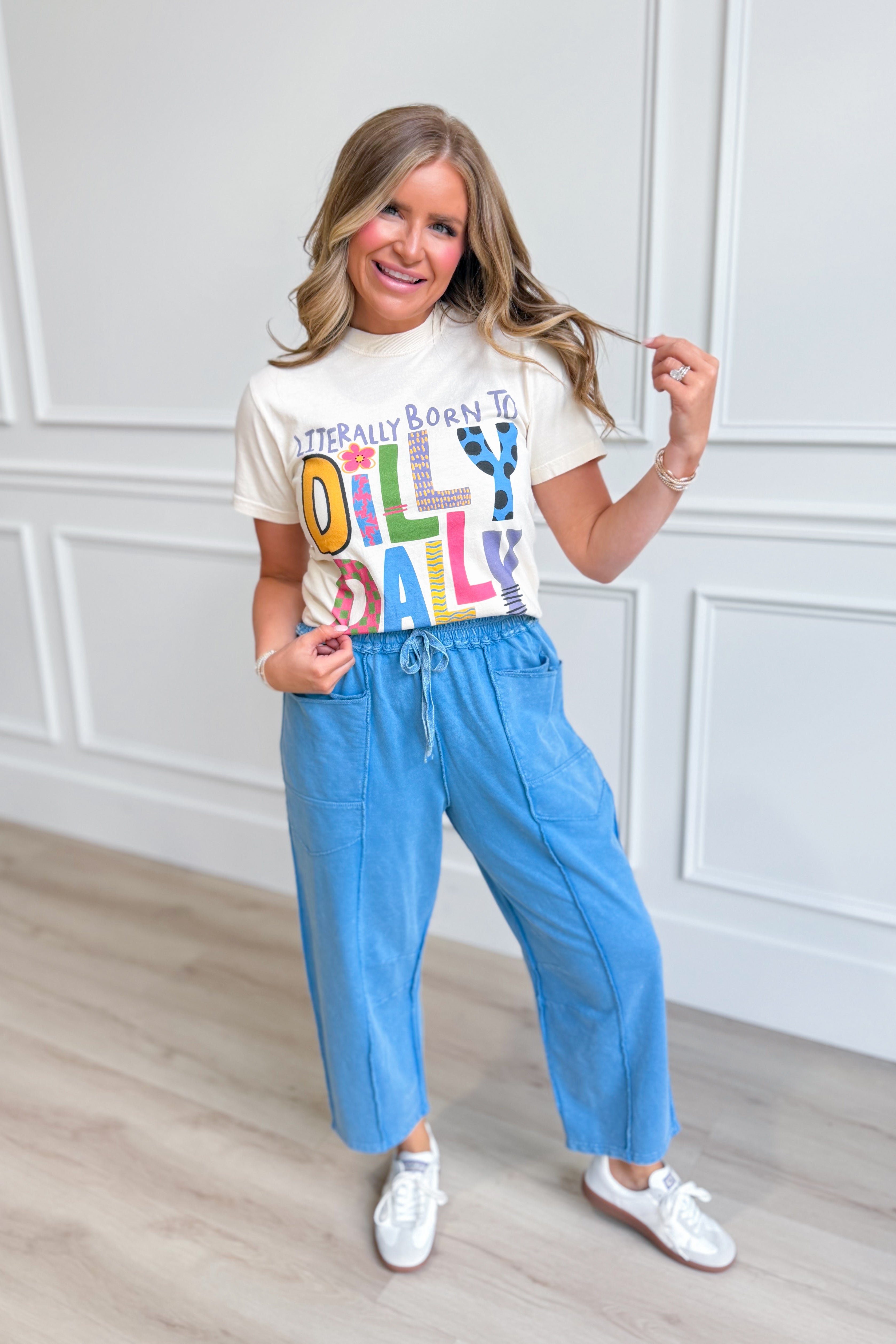 Popcorn-themed graphic T-shirt from POPPY & PINE featuring playful "Born To Dilly Dally" design on soft cotton fabric.