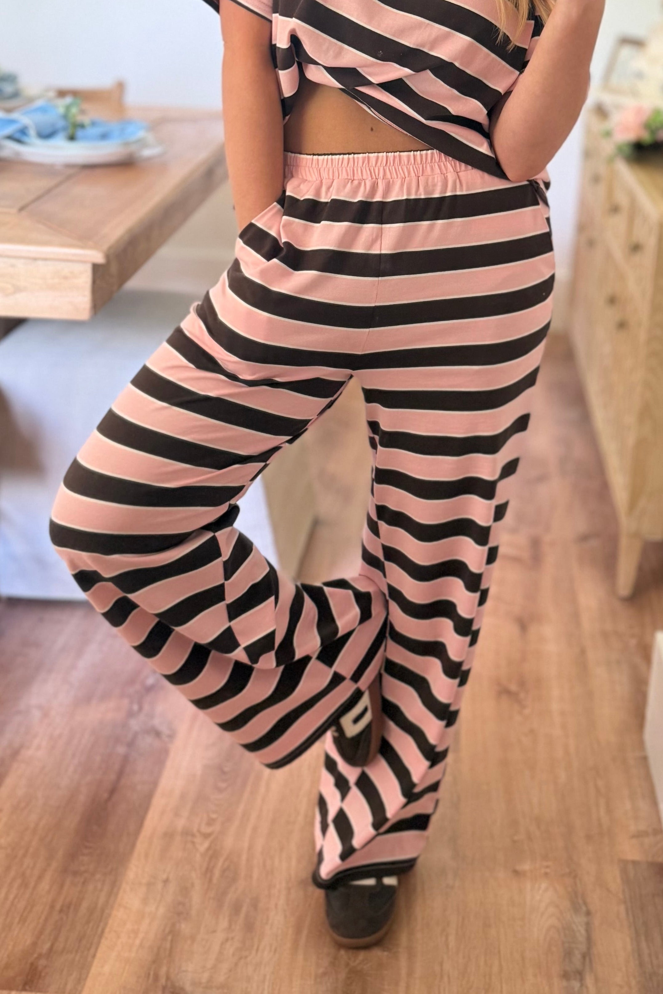 Striped wide-leg pants from THINGS BETWEEN featuring a relaxed fit and bold pattern, perfect for casual or stylish outfits.