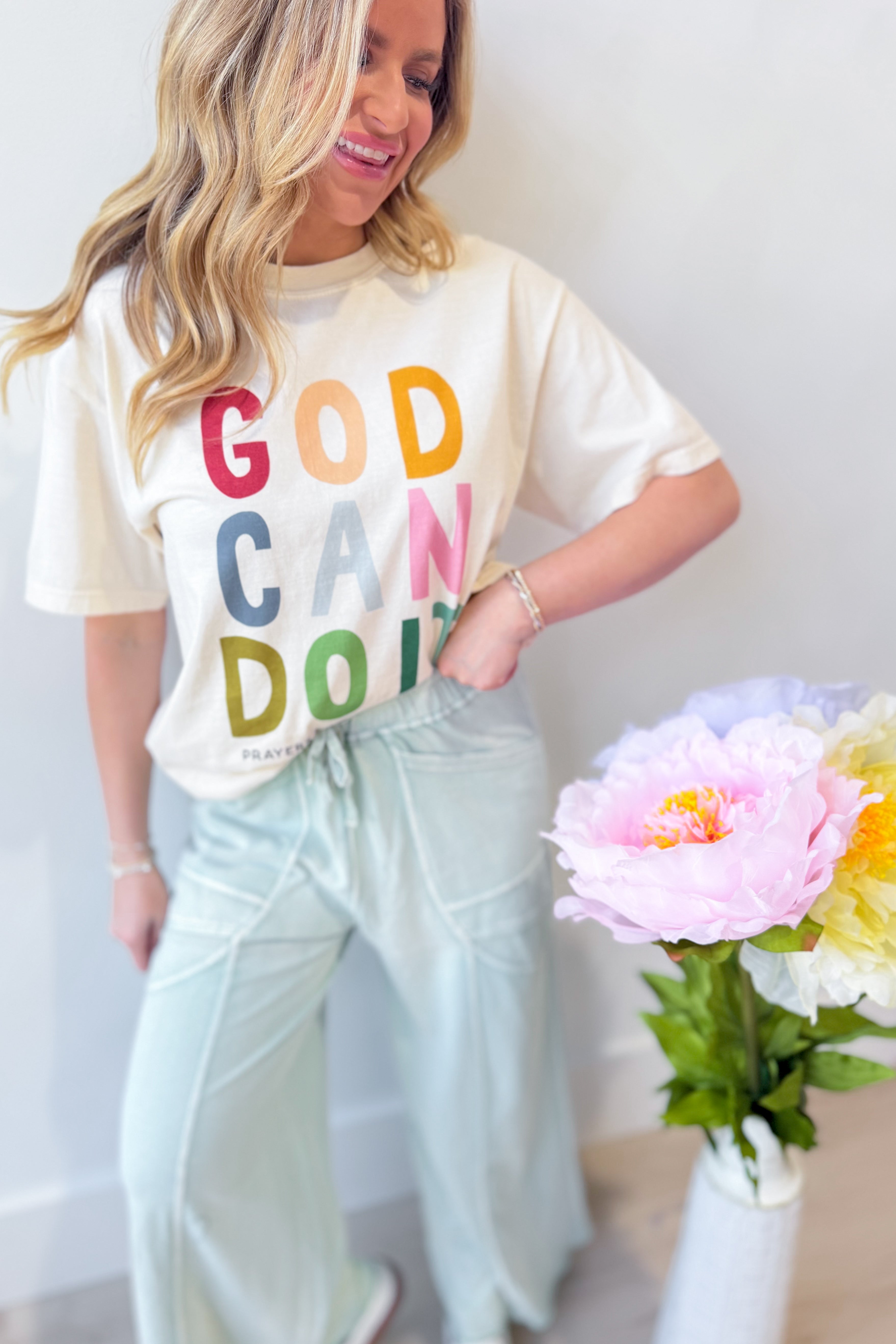 Poppy & Pine God Can Do It graphic T-shirt featuring bold text and a vibrant design on a casual cotton tee.