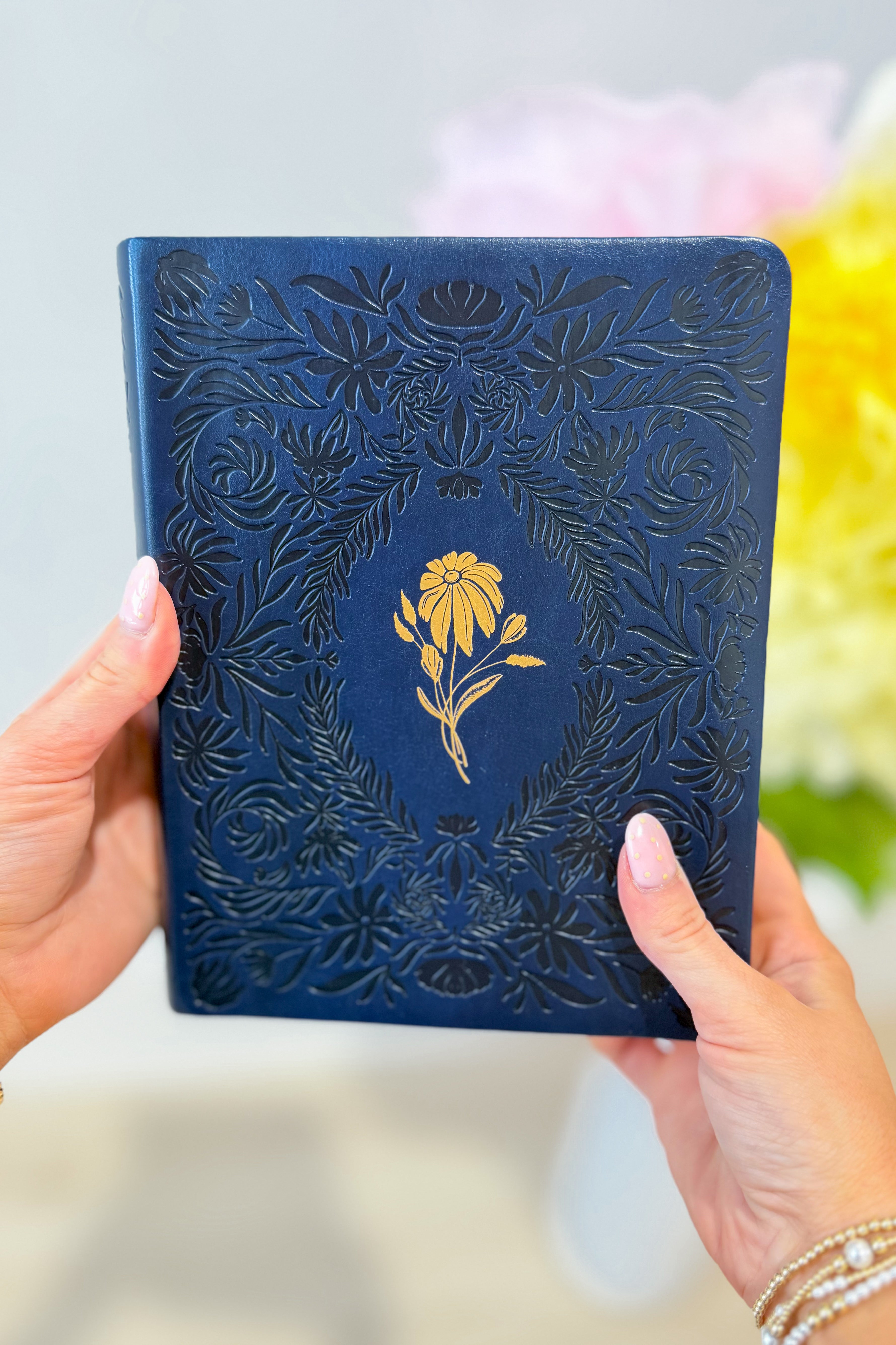 HOSANNA REVIVAL NLT Versailles Notetaking Bible in black leather with gold-edged pages and spacious margins for notes.