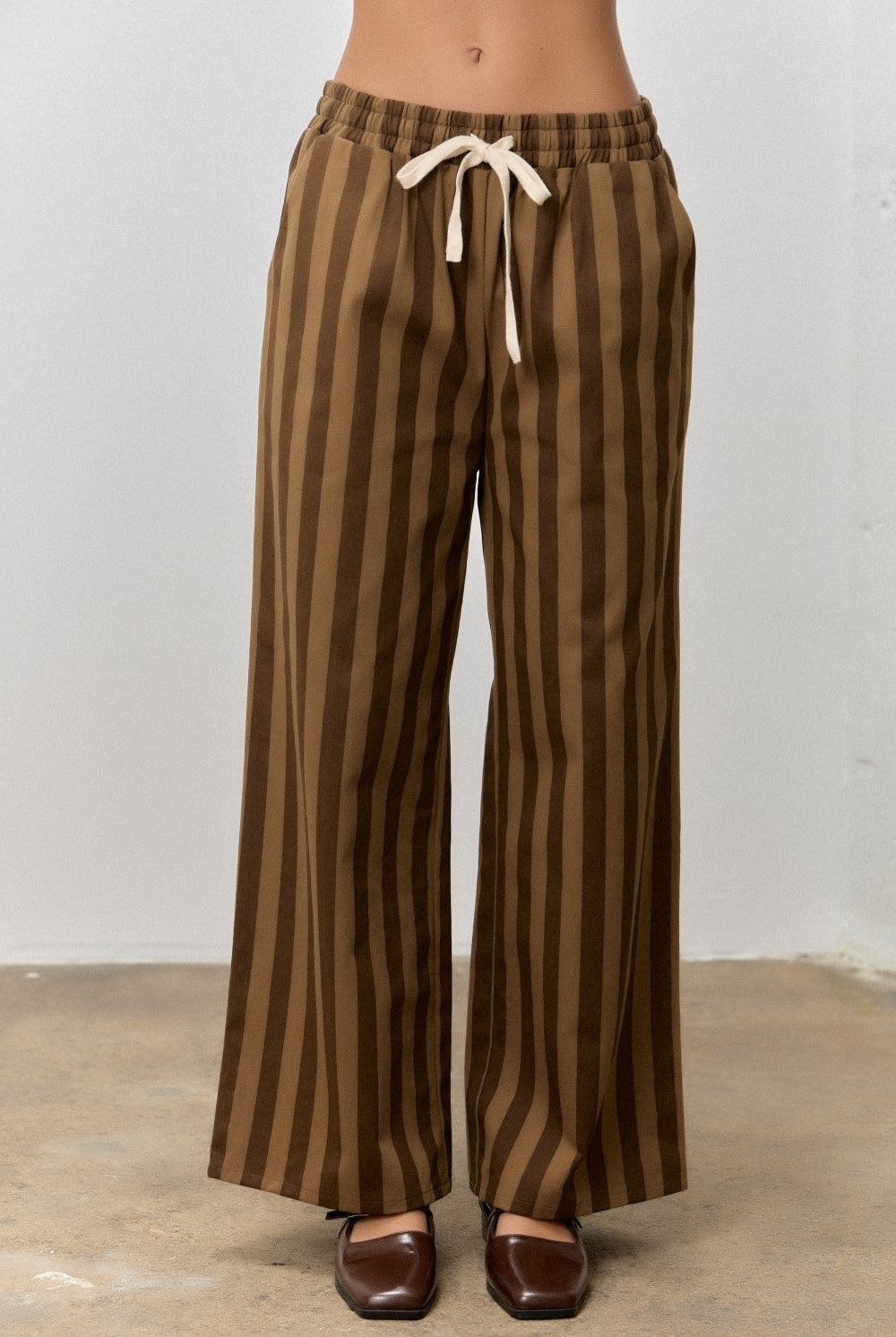 Kimmy Brown Striped Drawstring Pants by BAEVELY, featuring a relaxed fit with brown and white stripes and adjustable drawstring waist.