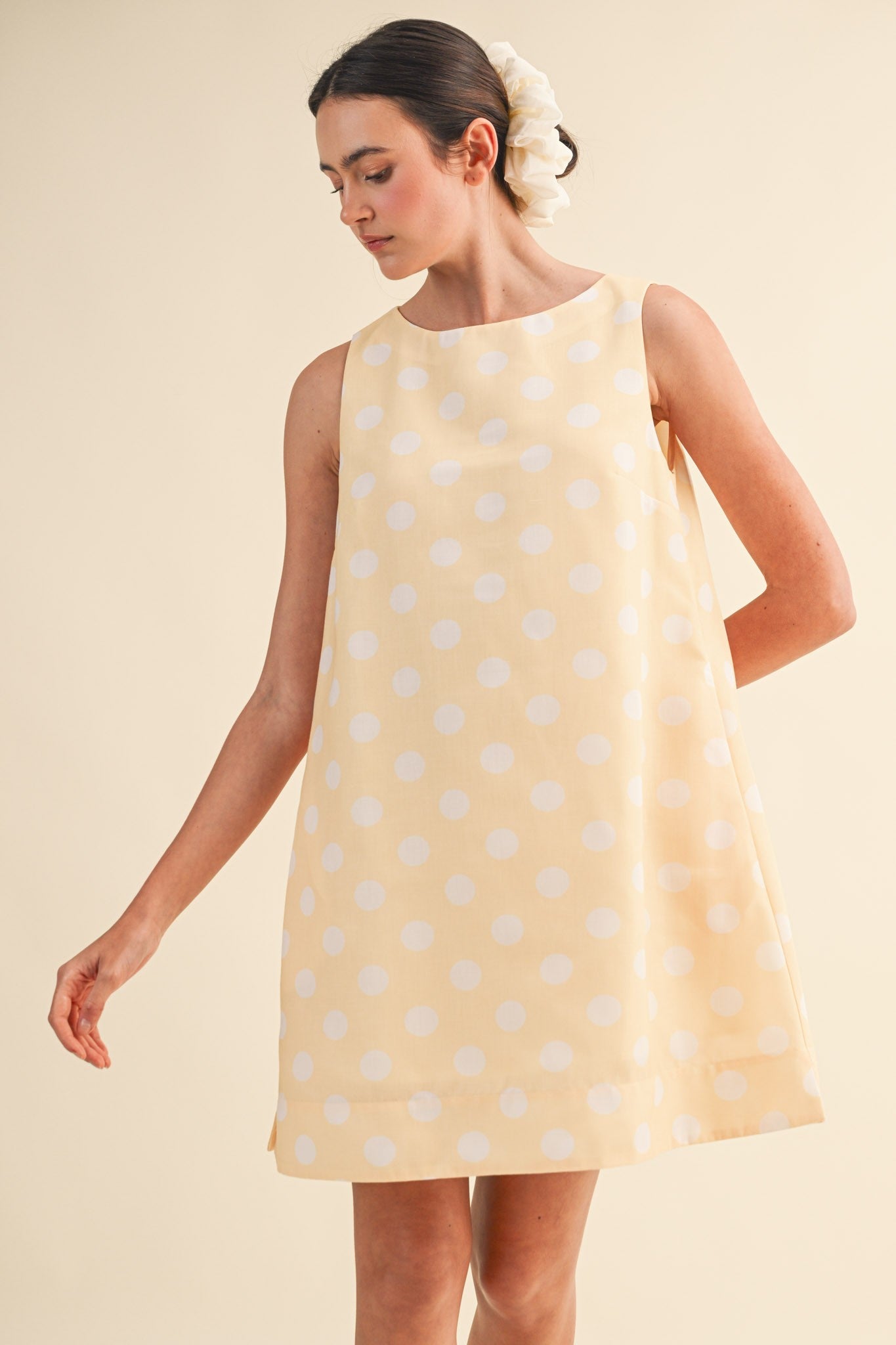 &MERCI Lola Polka Dot Sleeveless Dress with fitted bodice and flared skirt, featuring classic black and white polka dot pattern.