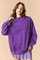 Purple Cynthia Game Day Graphic Sweatshirt by PEACH LOVE featuring bold game day design and comfortable fit.