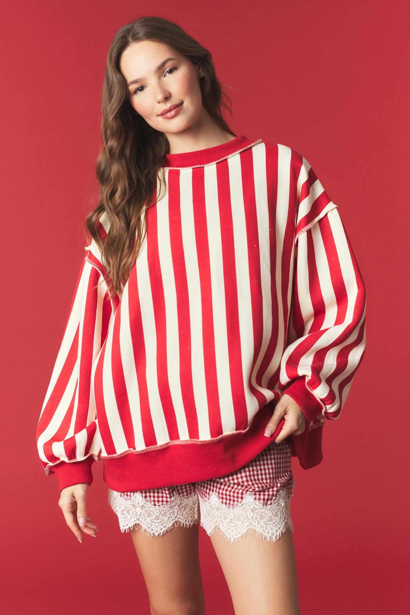 Red and white striped reversible sweatshirt from PEACH LOVE featuring festive "Merry" graphic, casual fit, and cozy fabric.