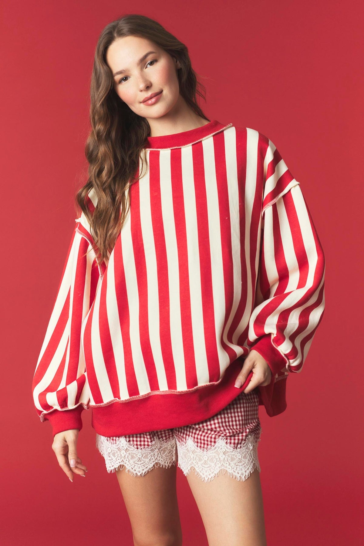 Red and white striped reversible sweatshirt from PEACH LOVE featuring festive "Merry" graphic, casual fit, and cozy fabric.