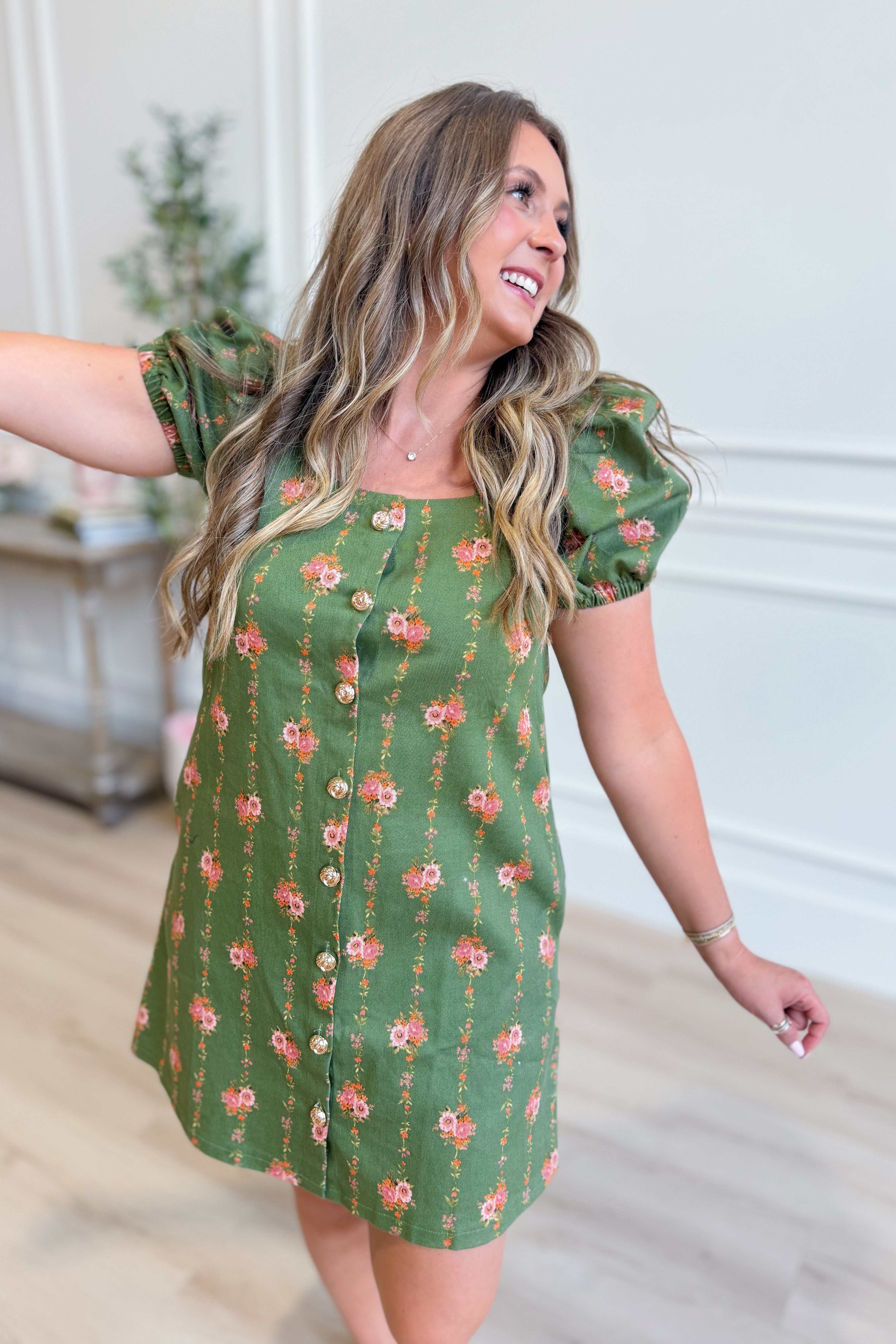 ENTRO Kelly floral button-down dress displayed on a hanger, featuring a vibrant floral pattern and classic shirt collar.