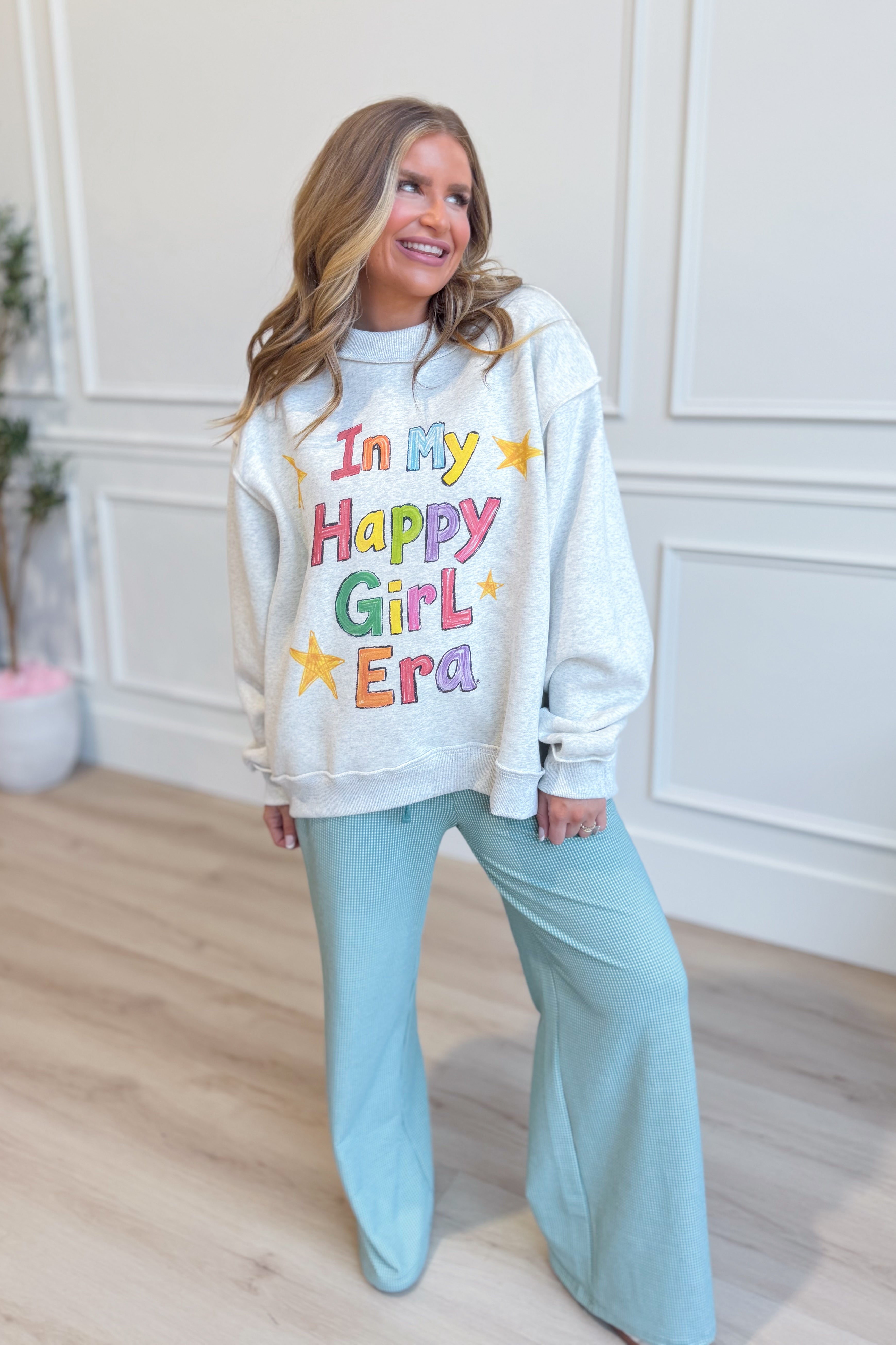 Reversible "In My Happy Girl Era" graphic sweatshirt by BUCKET LIST, showing vibrant colors and casual fit.
