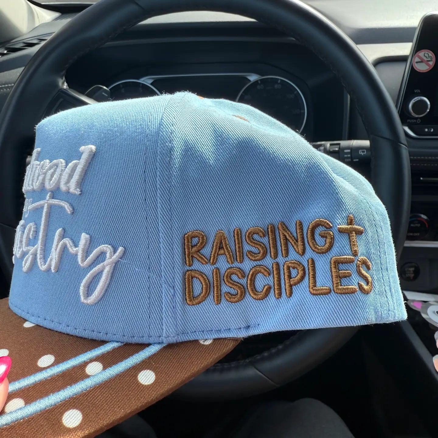 Broke Babe Motherhood Is My Ministry trucker hat with mesh back and embroidered text, stylish accessory for moms.