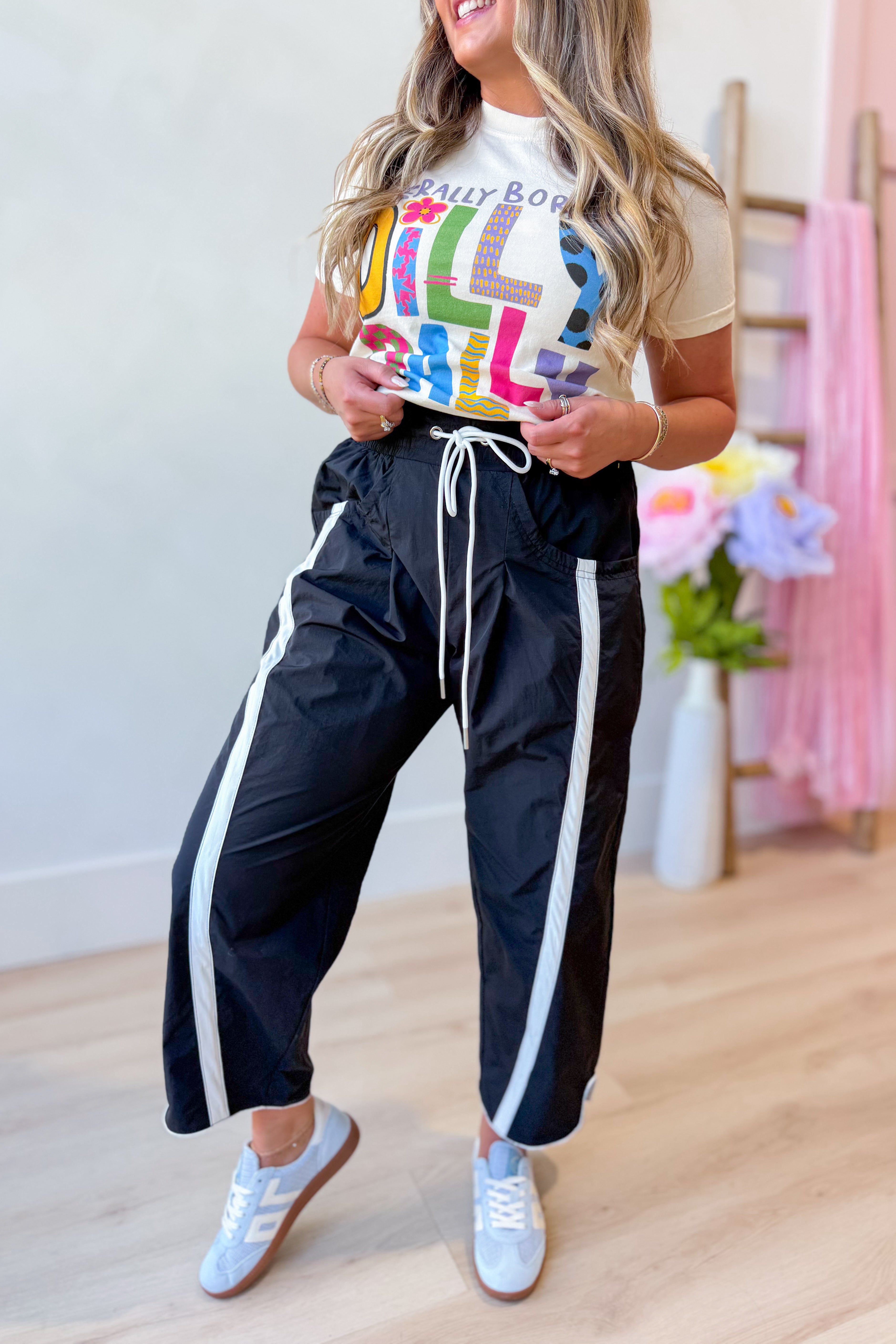 Lenny Black windbreaker contrasted stripe pant by BUCKET LIST, 156 pants style, showing the side view with contrasting stripe details.