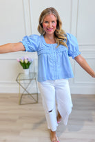 Light blue Holly puff sleeve frilly top from ENTRO, featuring ruffled details and a stylish, dressy design perfect for elegant outfits.