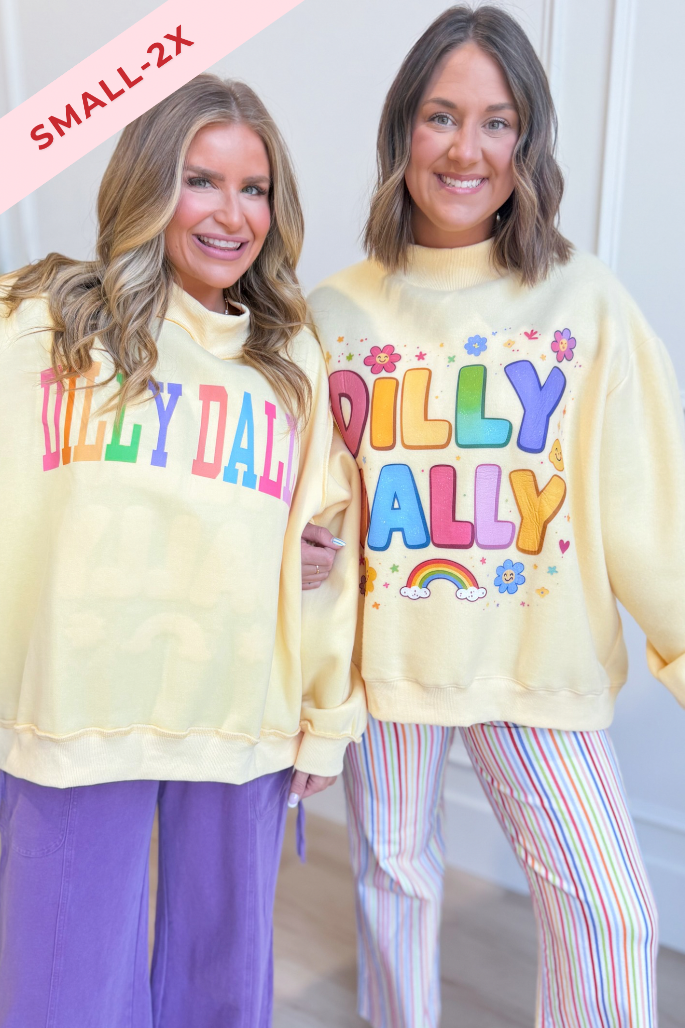 Two women modeling matching pale yellow sweatshirts with colorful 'DILLY DALLY' text and floral/rainbow graphics, paired with striped pants. A pink 'SMALL-2X' overlay appears in the top-left corner.