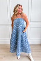 Aureum Mia Polka Dot Denim Dress featuring a fitted bodice, short sleeves, and a flared skirt with white polka dots on blue denim.