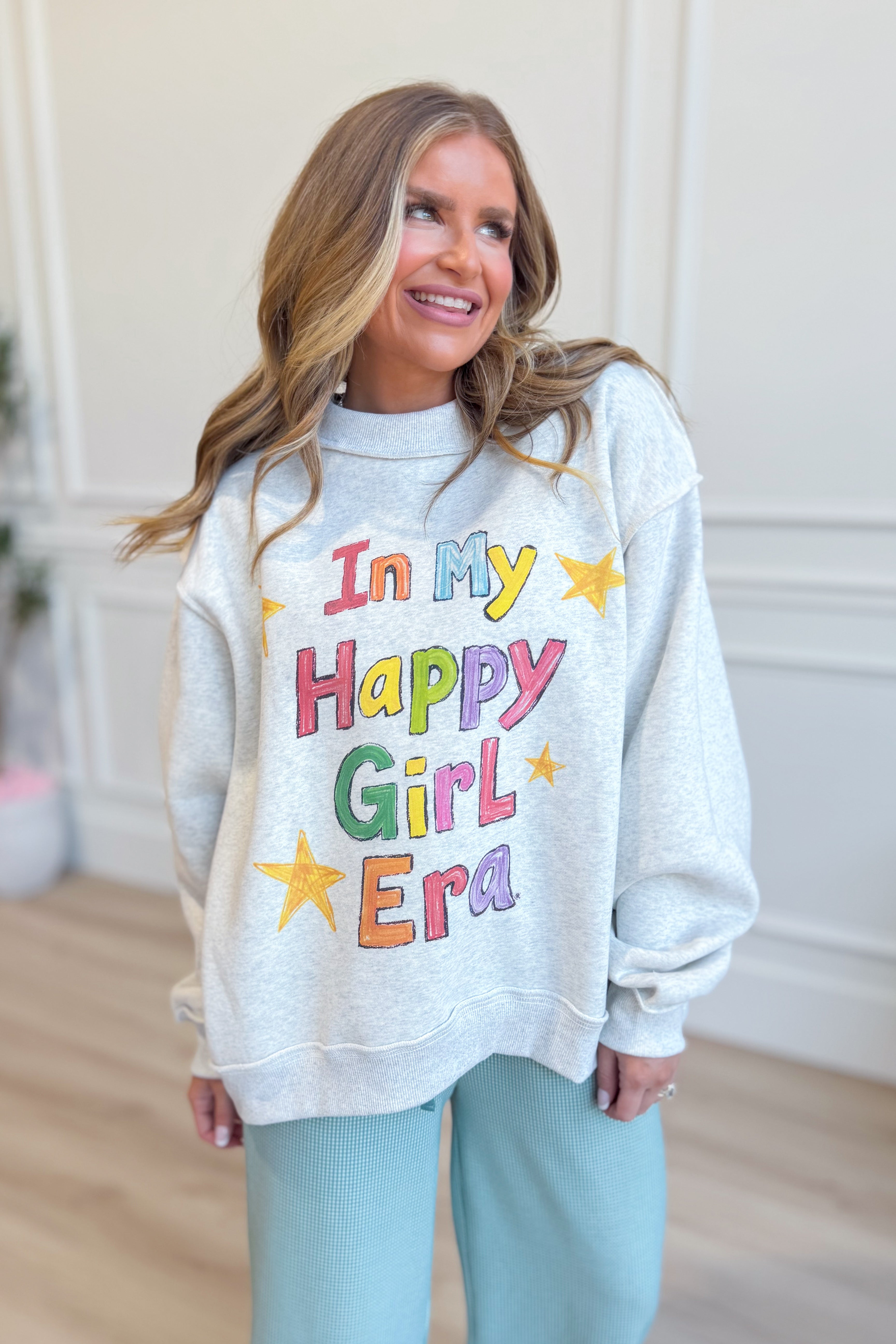 Reversible graphic sweatshirt from BUCKET LIST's In My Happy Girl Era collection, featuring colorful, stylish design.