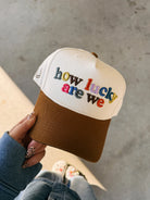 ETTA & EAST How Lucky Are We trucker hat with adjustable strap, featuring bold printed design on classic mesh cap.