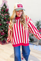 Red and white striped reversible sweatshirt from PEACH LOVE, featuring a festive merry graphic on the front.