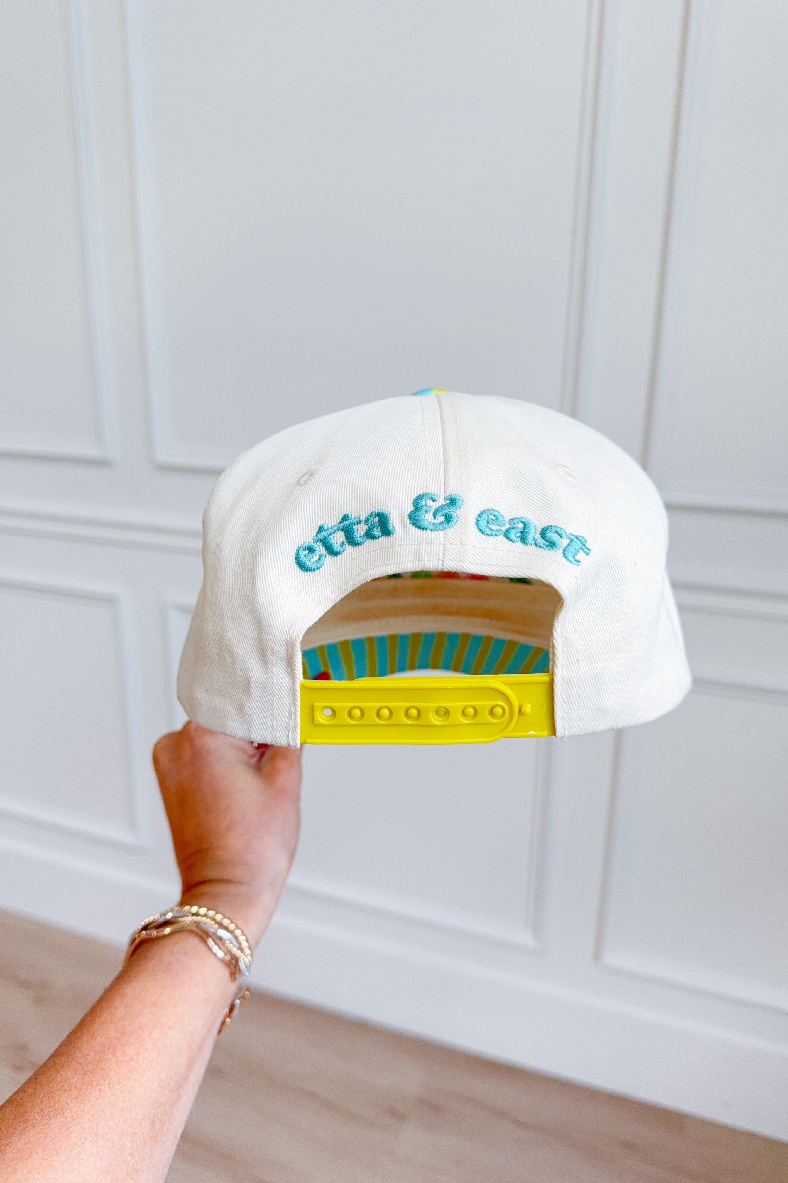 ETTA & EAST Living On A Dream trucker hat with mesh back and embroidered logo, casual accessory for everyday wear.