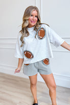 Peach Love Laurel Gingham Ruffled Football Patched top, casual 105 top with gingham pattern and ruffled details, front view.