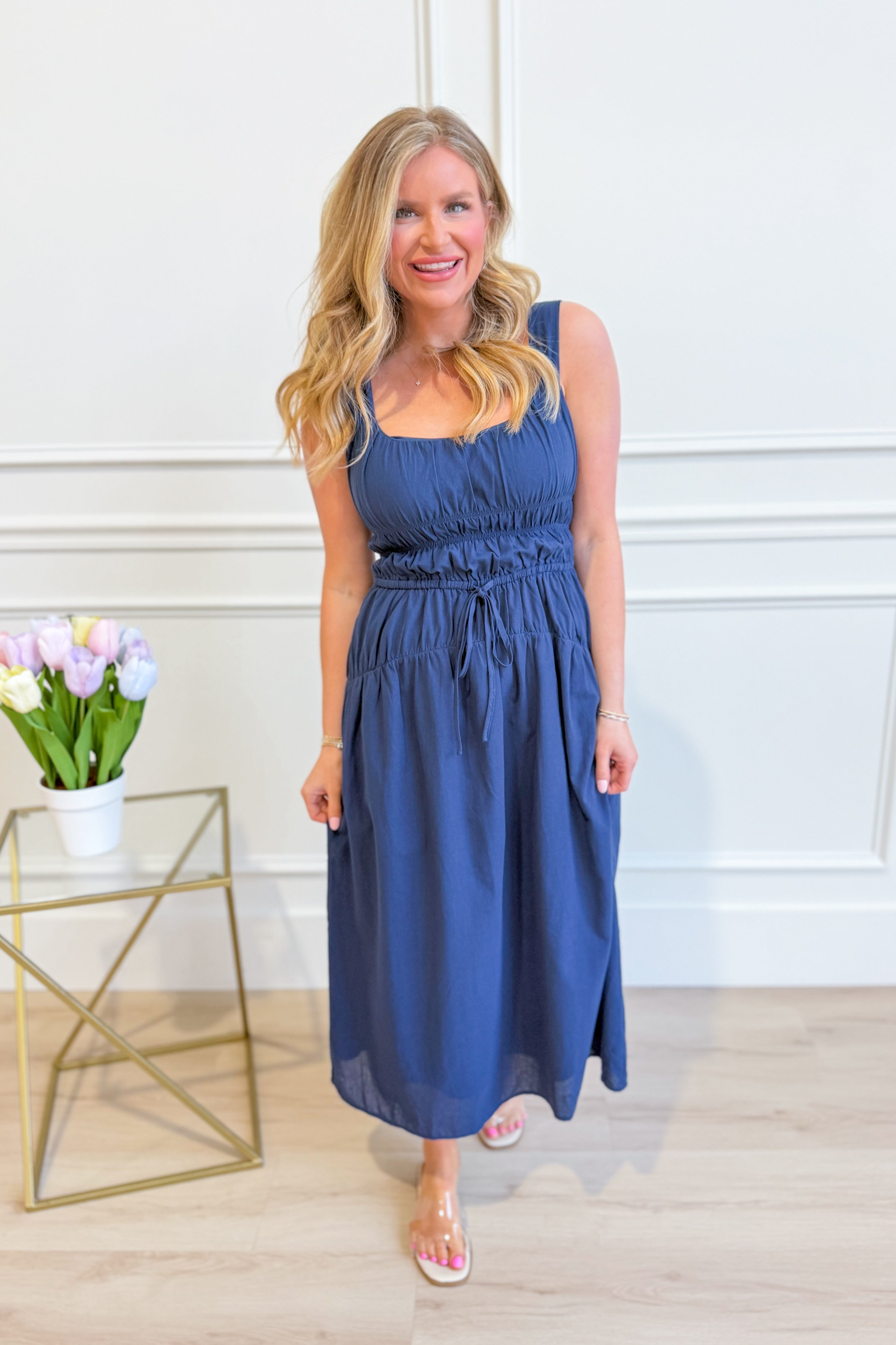 Baevely Cindy smocked tie waist midi dress in a flowy fabric, featuring a fitted bodice and a relaxed, elegant silhouette.