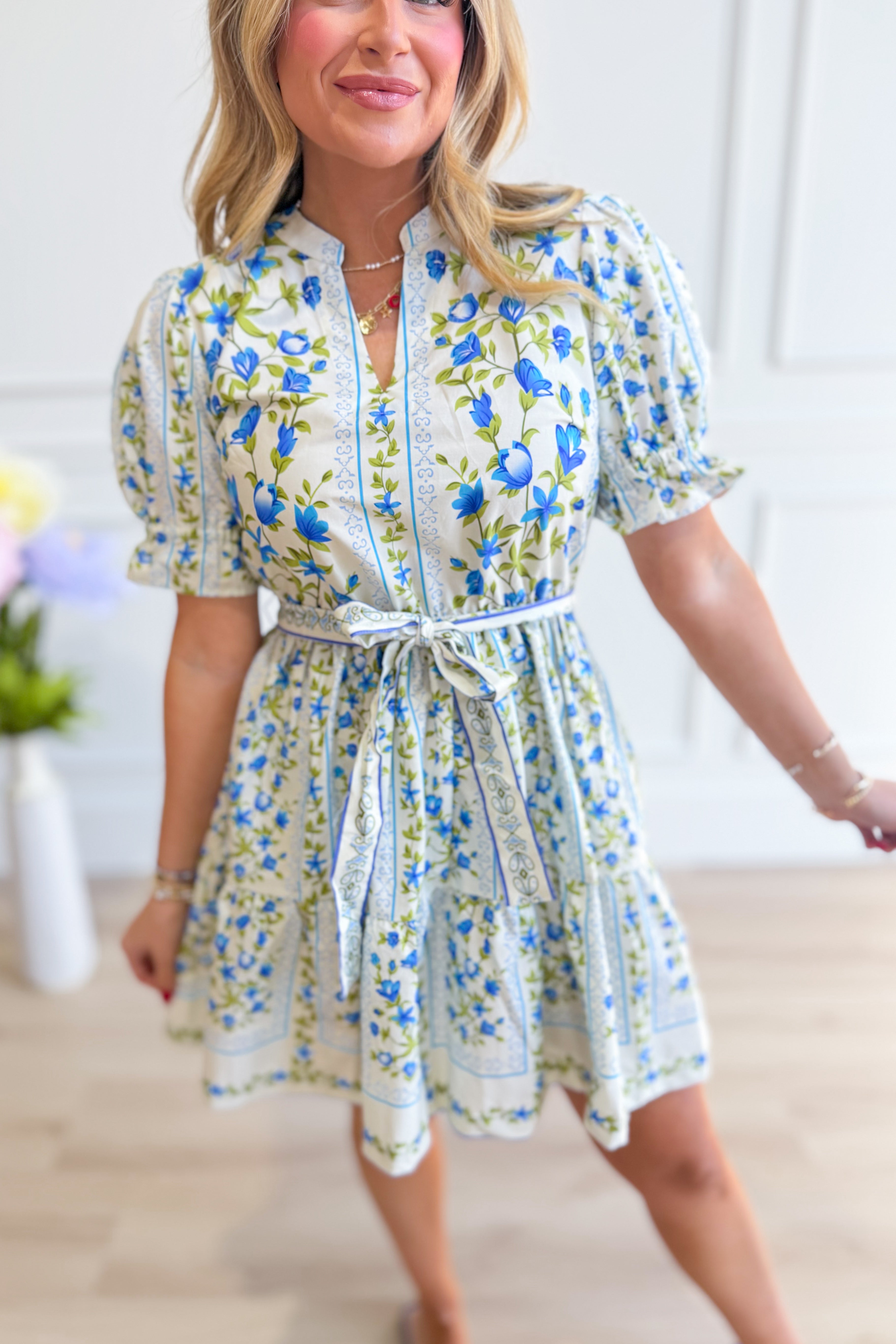 EE:SOME Bella floral printed tie waist dress with a flowy skirt and vibrant floral pattern, perfect for dressy occasions.