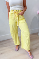 Yellow mineral-washed eyelet barrel jeans by PEACH LOVE from the 147 Novelty Jeans collection, showcasing distressed denim details.