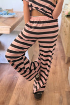 Striped wide-leg pants from THINGS BETWEEN featuring a relaxed fit and bold pattern, perfect for casual or stylish outfits.