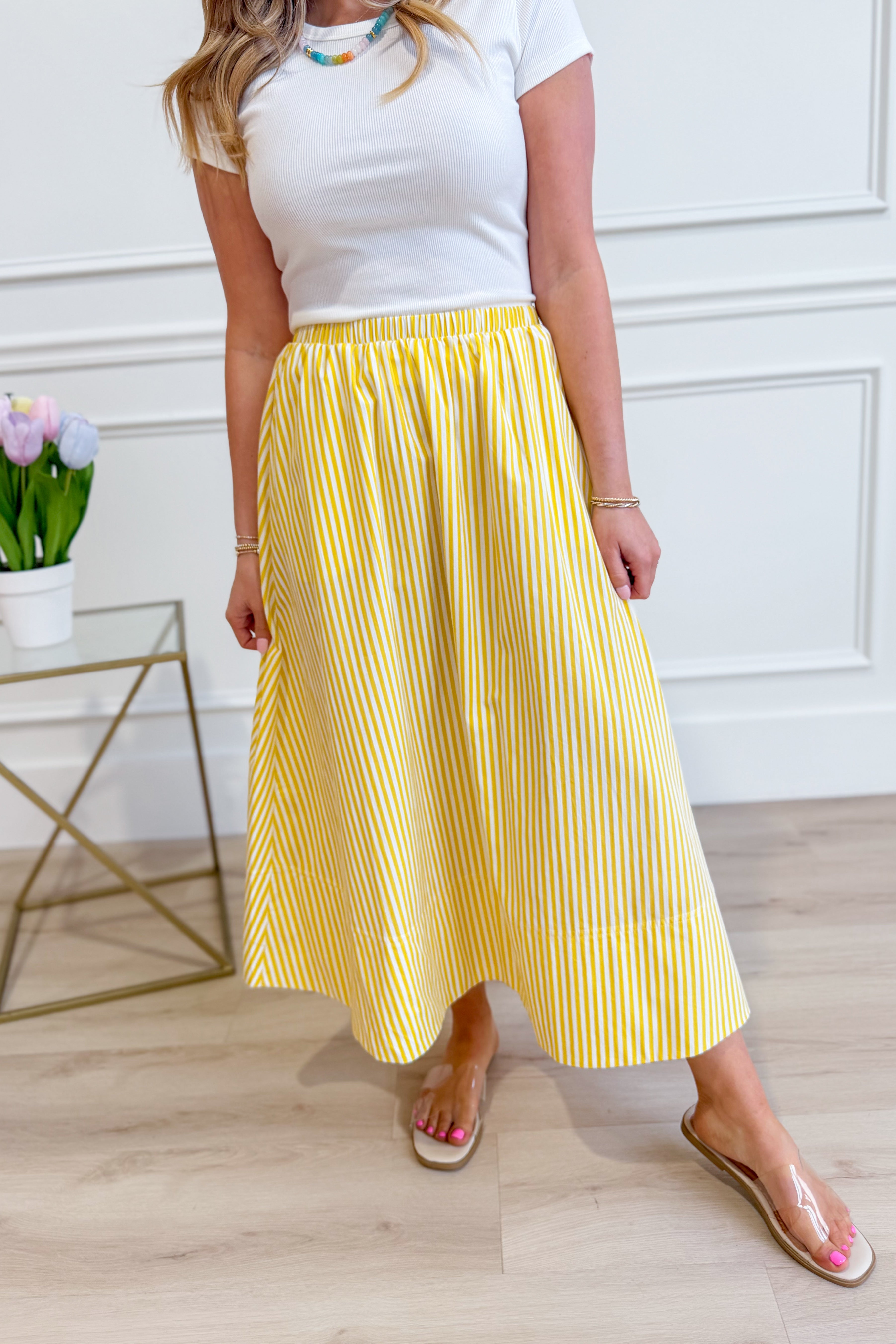 HYFVE Lola striped midi skirt displayed on a hanger with a high waist and colorful vertical stripes.