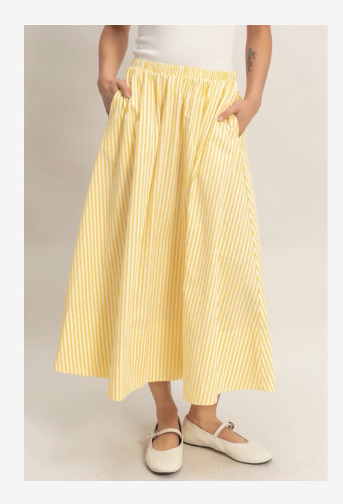 HYFVE Lola striped midi skirt with a fitted waist and flowing hem, featuring bold vertical stripes in black and white.