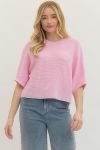 Pink knitted spring top by ENTRO, casual 105 top with a textured knit pattern, worn on a model with a relaxed fit.