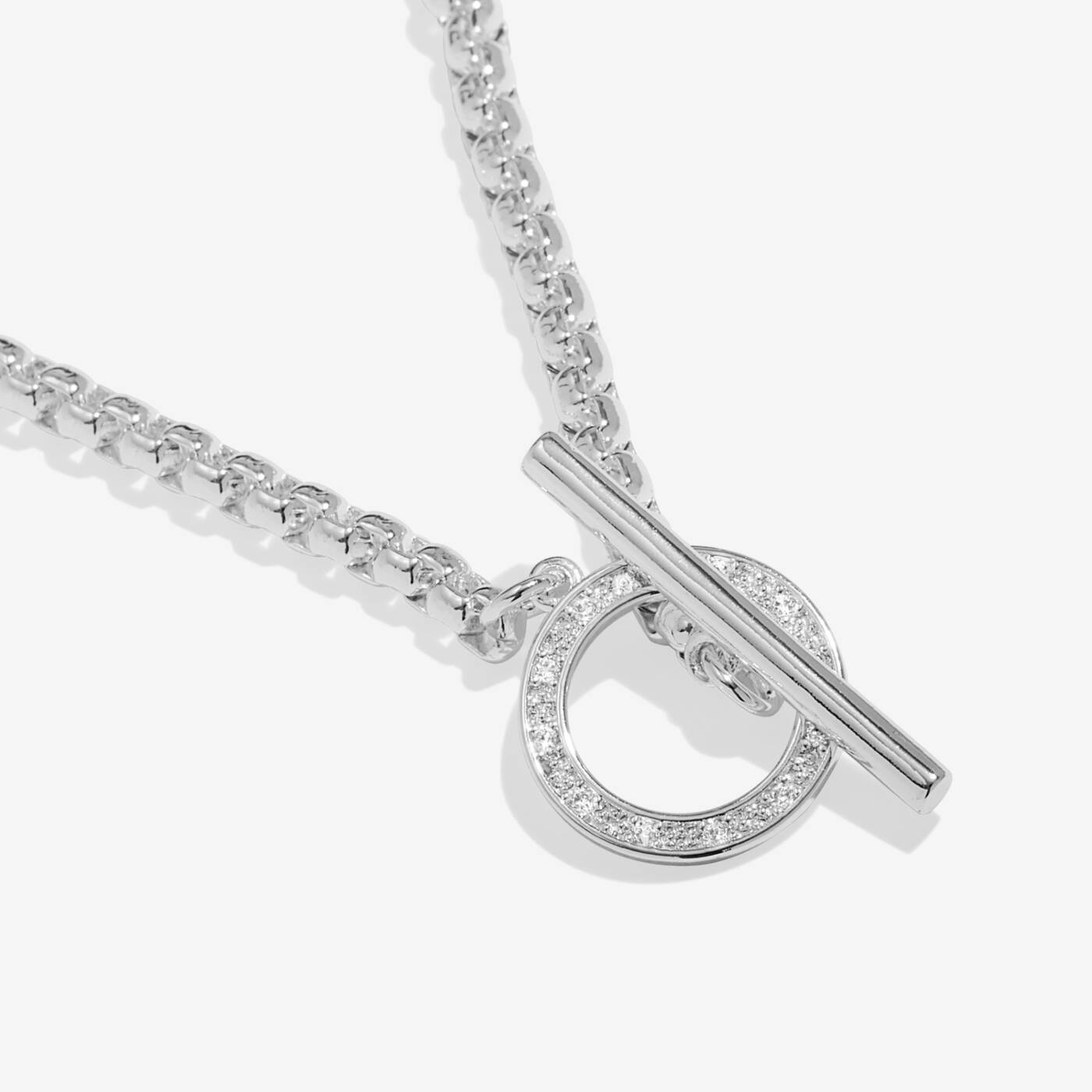 A LITTLES & CO Evermore Circle T Bar 16-inch necklace featuring a sleek silver chain with a circular pendant and T-bar clasp.