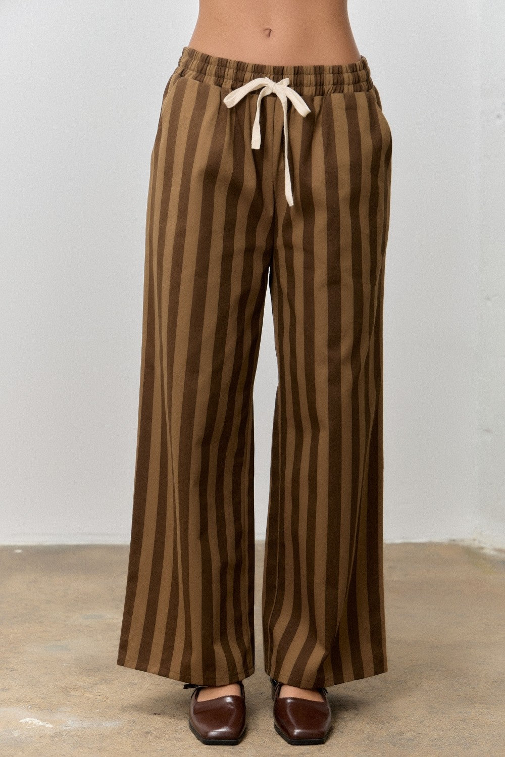 Kimmy Brown Striped Drawstring Pants by BAEVELY, featuring a relaxed fit with brown and white stripes and adjustable drawstring waist.